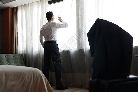 男士玫瑰背影青年男士站在酒店房间里背景