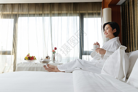 年轻女人在酒店房间里喝咖啡图片