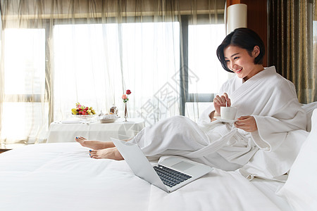 年轻女人在酒店房间里使用电脑图片