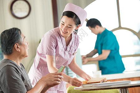 餐厅工作人员护士照顾老年人用餐背景