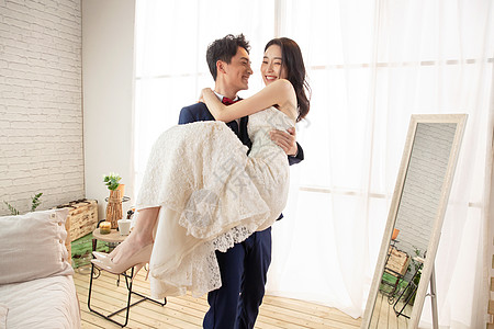 卧室里幸福的丈夫抱着妻子高清图片