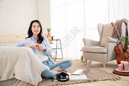 年轻的女青年坐在地毯上图片