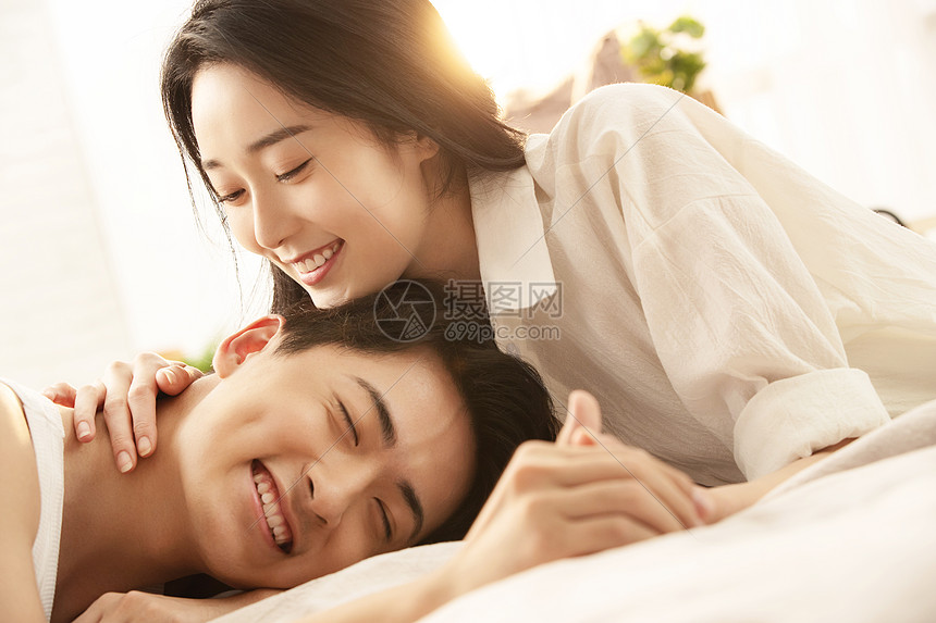 亲密的年轻情侣在床上享受甜蜜时光图片