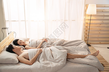 年轻情侣躺在床上睡觉图片