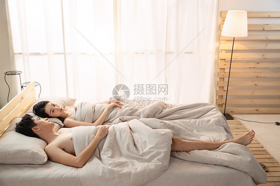 年轻情侣躺在床上睡觉图片