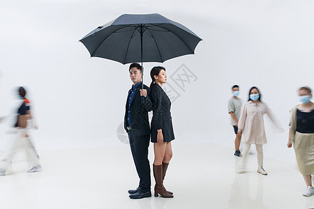 拿着雨伞的商务男女站在人群中图片
