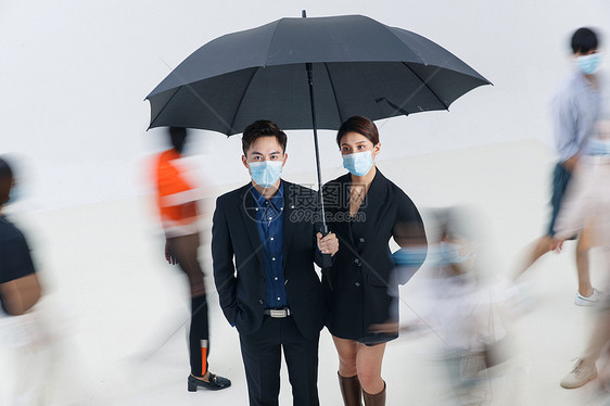 拿着雨伞的商务男女戴着口罩站在人群中图片