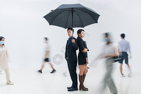 拿着雨伞的商务男女站在人群中图片