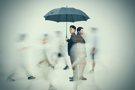 拿着雨伞的商务男女站在人群中图片