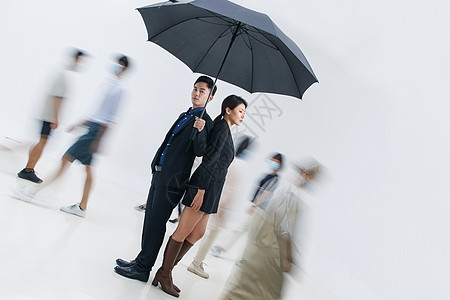 拿着雨伞的商务男女站在人群中图片