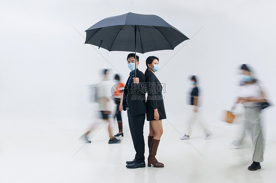 拿着雨伞的商务男女戴着口罩站在人群中图片