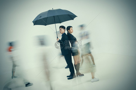 拿着雨伞的商务男女站在人群中图片