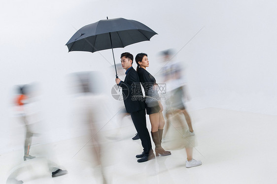 拿着雨伞的商务男女站在人群中图片