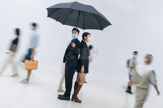 拿着雨伞的商务男女戴着口罩站在人群中图片