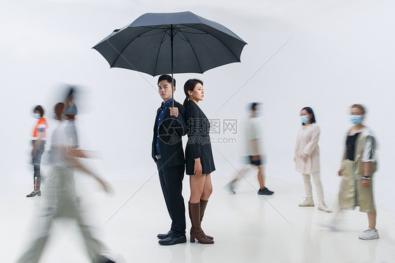 拿着雨伞的商务男女站在人群中图片