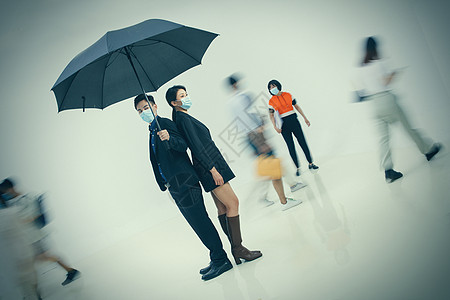 拿着雨伞的商务男女戴着口罩站在人群中图片