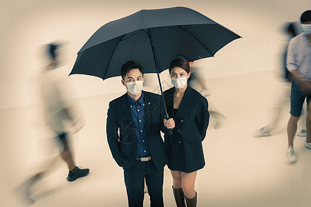 拿着雨伞的商务男女戴着口罩站在人群中图片