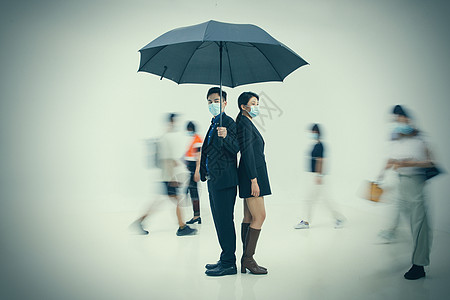 拿着雨伞的商务男女戴着口罩站在人群中图片