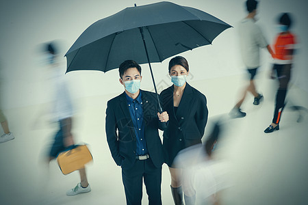 拿着雨伞的商务男女戴着口罩站在人群中图片