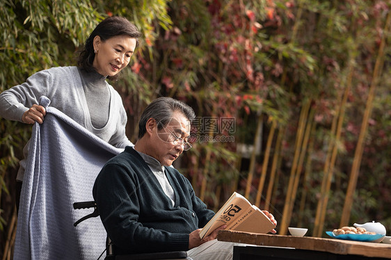 户外照顾丈夫的老年女人图片