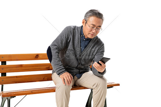 坐在长椅上的老人看手机图片