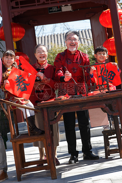 祖父母和孙辈四人一起写春联图片