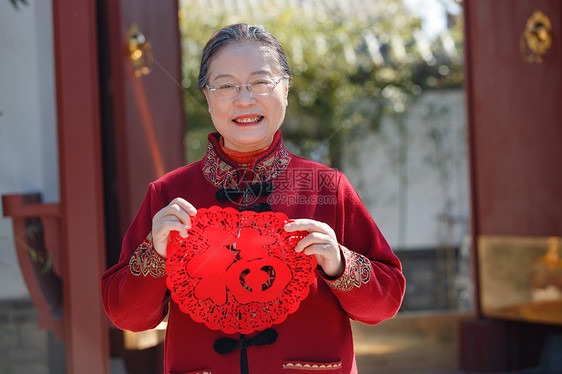 老年女人手拿窗花庆祝新年图片