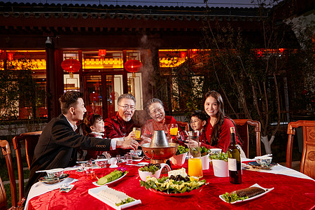 东方家庭在中式庭院内干杯庆祝新年图片
