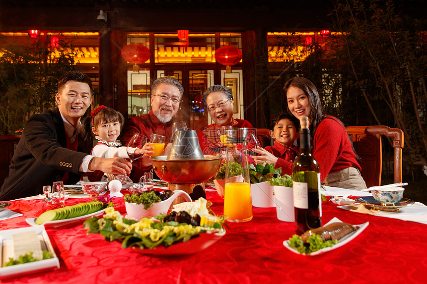 东方家庭在中式庭院内干杯庆祝新年图片