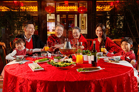 东方家庭在中式庭院内干杯庆祝新年图片