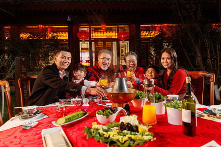 东方家庭在中式庭院内干杯庆祝新年图片