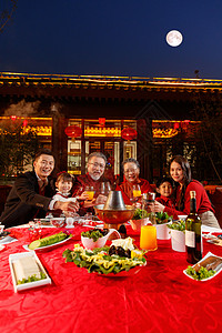 东方家庭在中式庭院内干杯庆祝新年图片