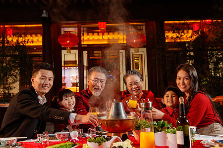 东方家庭在中式庭院内干杯庆祝新年背景图片