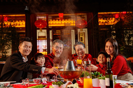 东方家庭在中式庭院内干杯庆祝新年图片