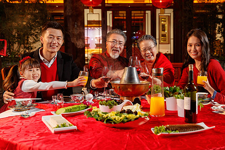 东方家庭在中式庭院内干杯庆祝新年图片