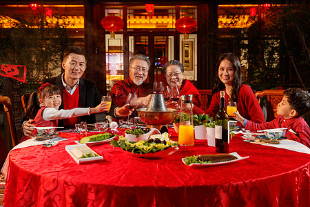 东方家庭在中式庭院内干杯庆祝新年图片