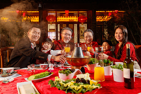 东方家庭在中式庭院内干杯庆祝新年图片