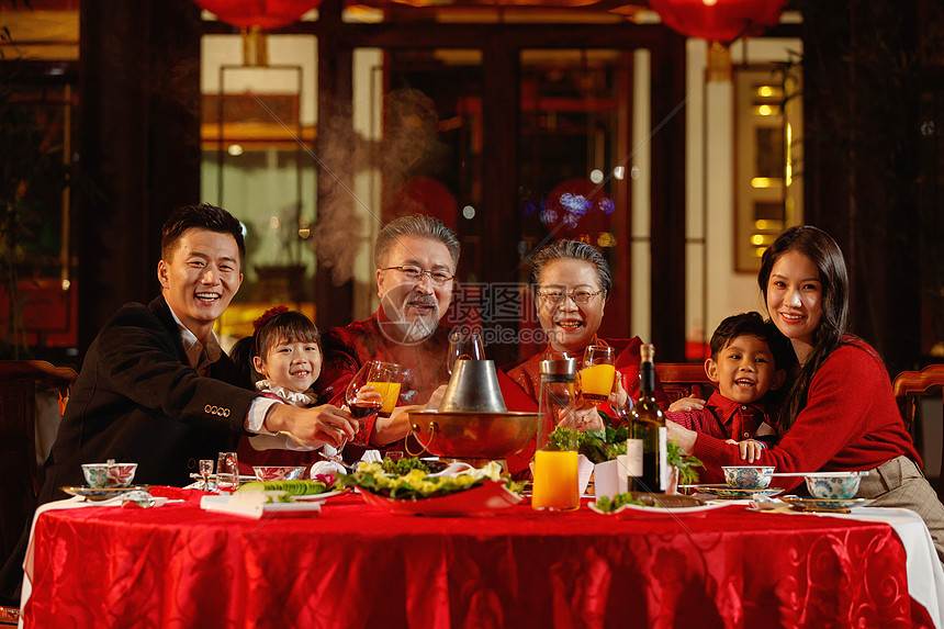 东方家庭在中式庭院内干杯庆祝新年图片