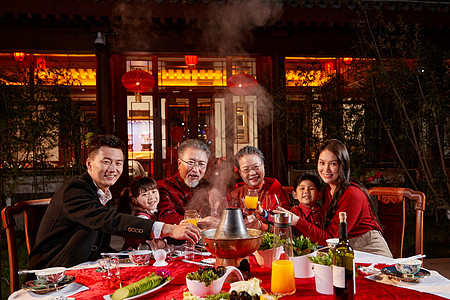 酒红色东方家庭在中式庭院内干杯庆祝新年背景