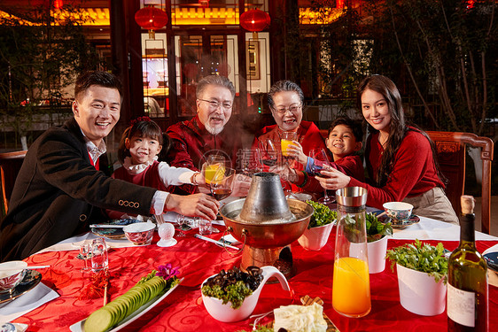 东方家庭在中式庭院内干杯庆祝新年图片