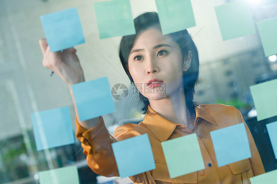 商务女士在办公室的便签纸上写字图片