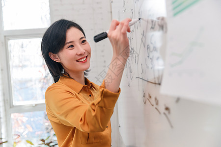 商务女士在办公室的白板上写字图片