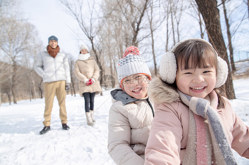 欢乐家庭在雪地上玩雪橇图片