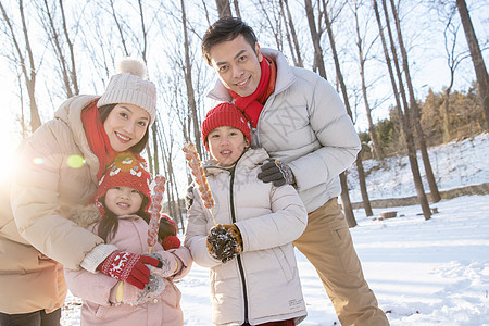 雪地里拿着糖葫芦的快乐家庭图片