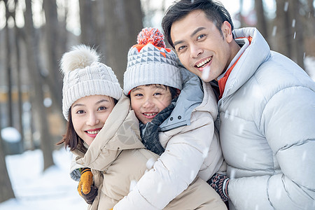 在雪地上玩耍的一家三口图片