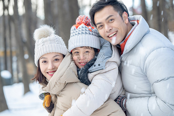 在雪地上玩耍的一家三口图片