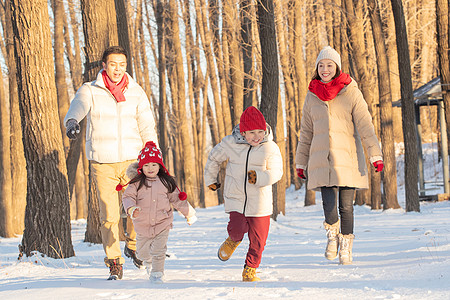 雪树林欢乐家庭在雪地里奔跑背景