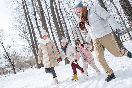 欢乐家庭在雪地里奔跑高清图片
