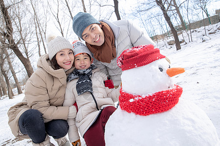 一家三口在雪地里堆雪人图片