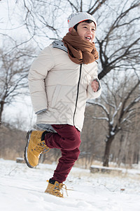 快乐的小男孩在雪地里玩耍图片